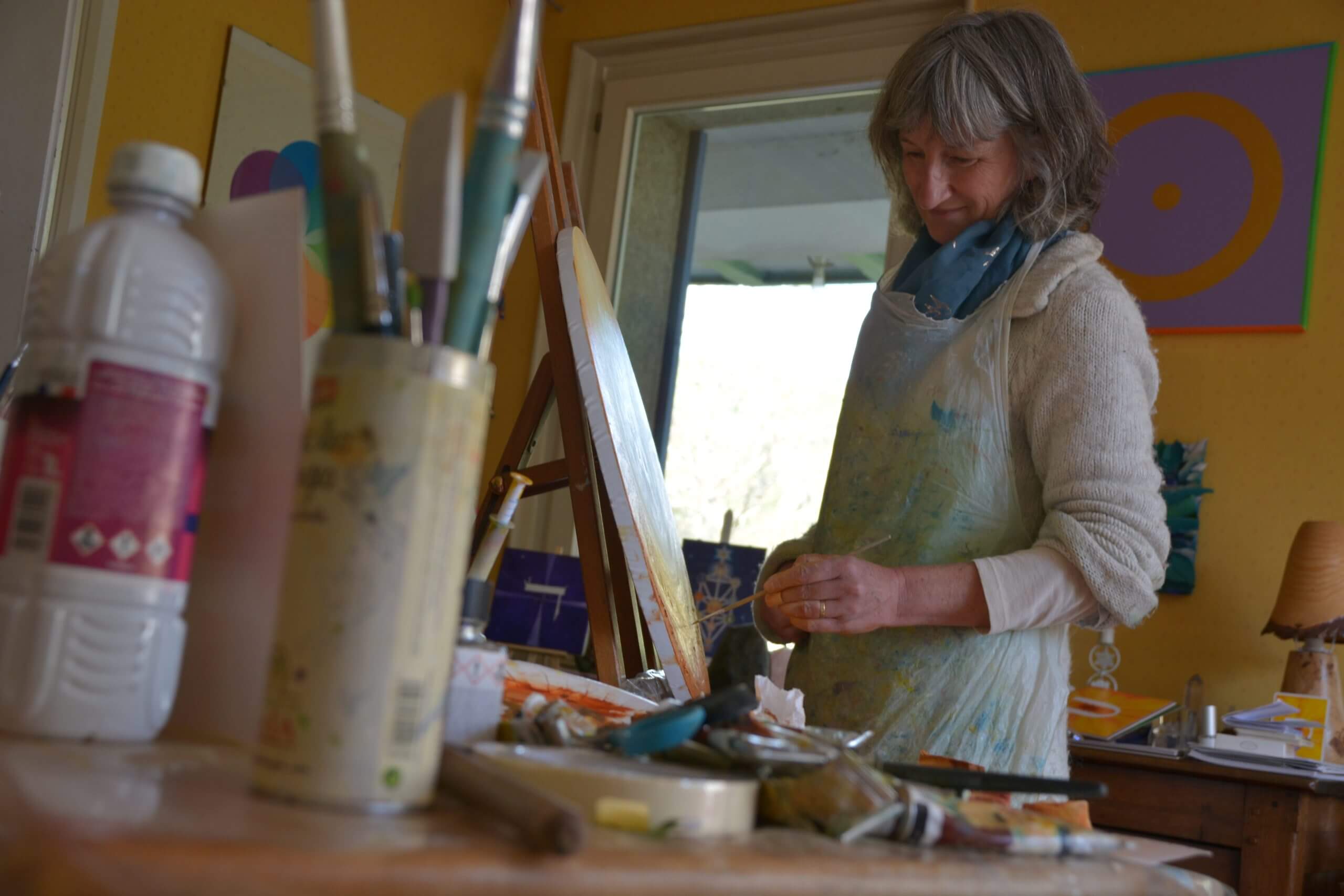 Nadine André artiste peintre peint dans son atelier